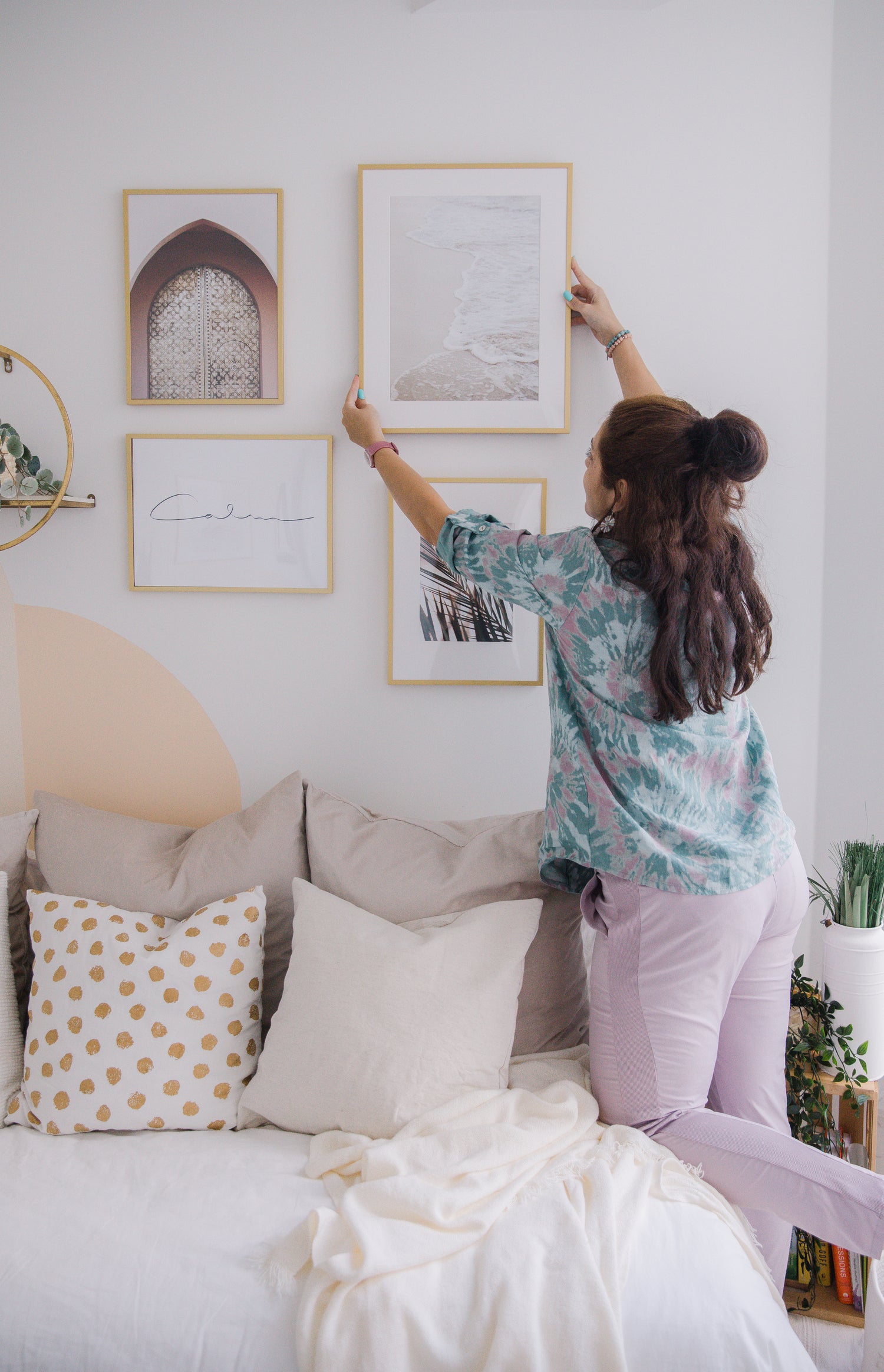 person-reaching-to-hang-a-frame-on-the-wall.jpg